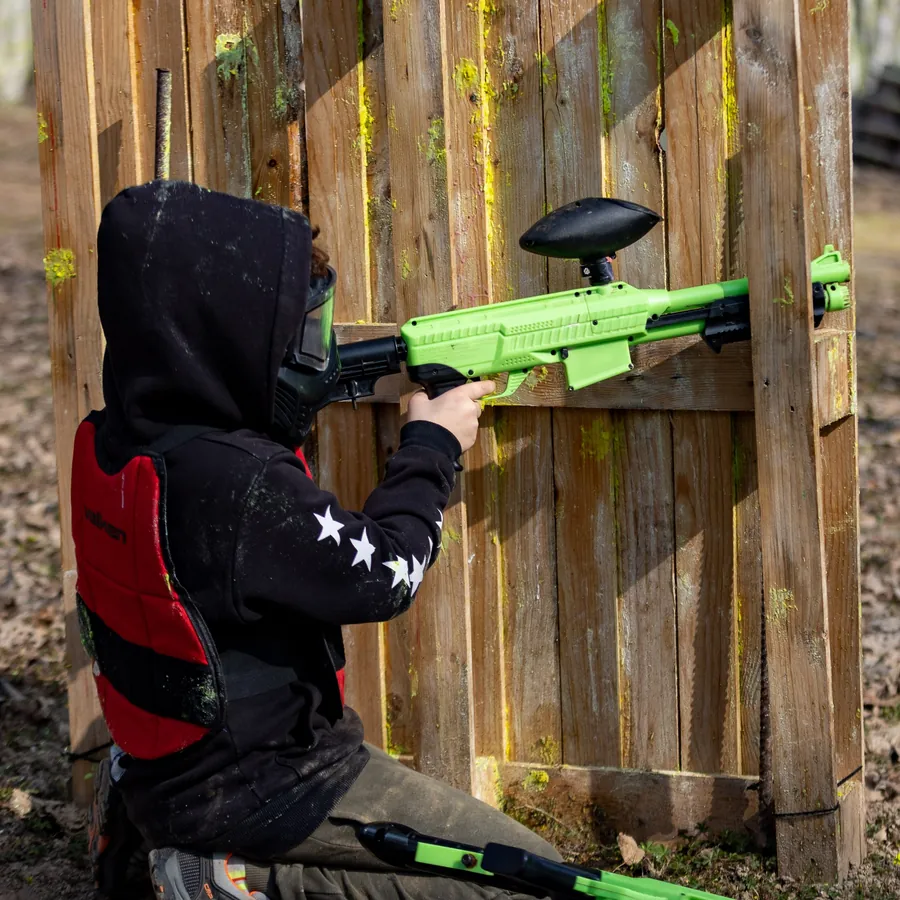 A young student of the kids course taking aim behind a barricade