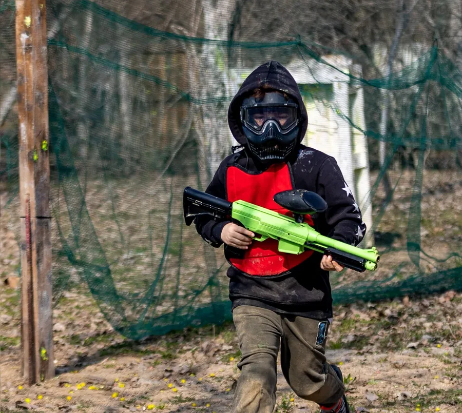 A boy from the kids course running across the field with his marker